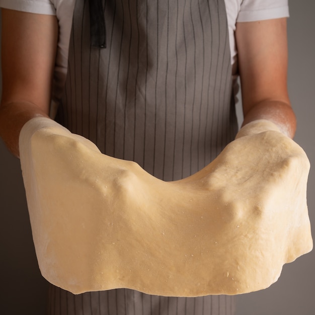 Photo gratuite chef d'étirement de la pâte avec ses mains