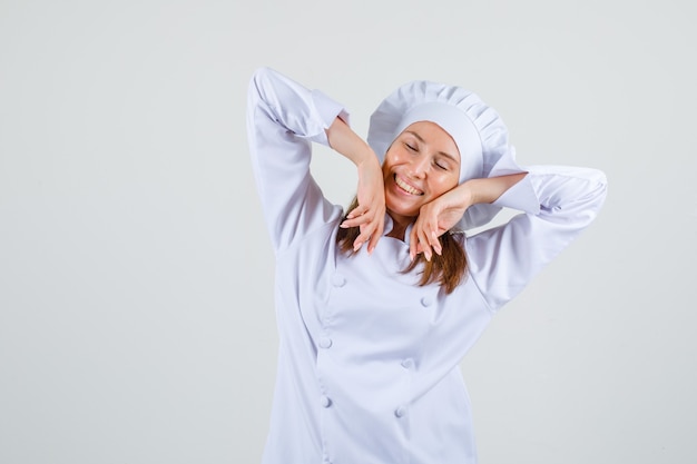 Chef féminin étirement des bras en uniforme blanc et à la détente