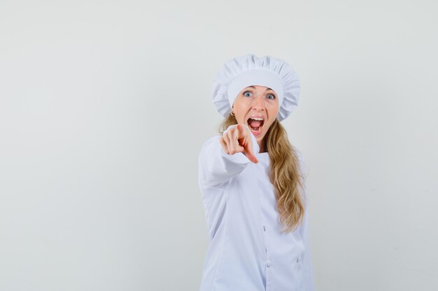 Chef féminin pointant sur la caméra tout en criant en uniforme blanc