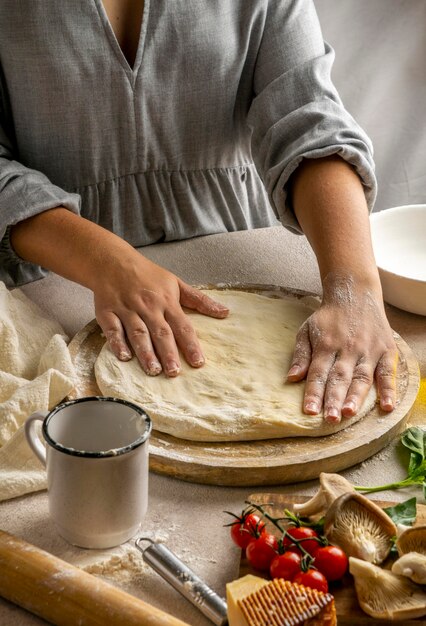 Chef féminin qui s'étend de la pâte à pizza