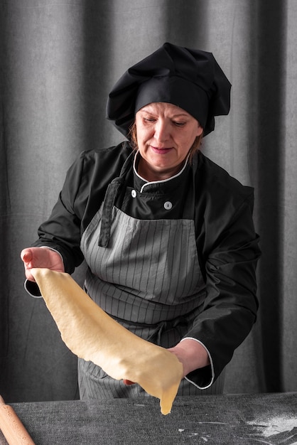 Chef féminin tenant la feuille de pâte