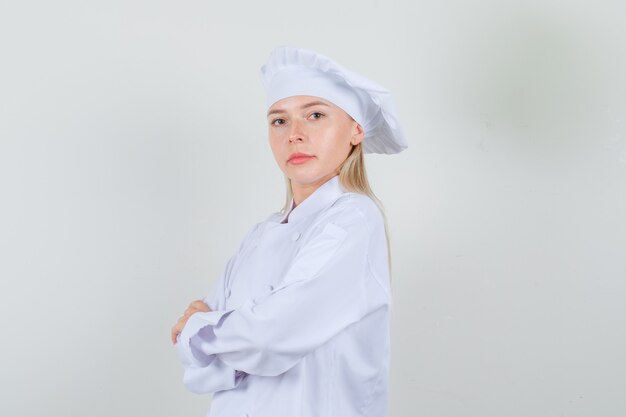 Chef féminin en uniforme blanc debout avec les bras croisés et à la confiance