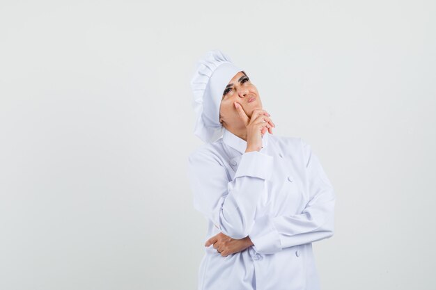 Chef féminin en uniforme blanc et à l'indécision