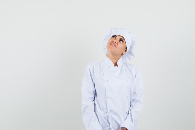 Chef féminin en uniforme blanc et à la recherche d'espoir