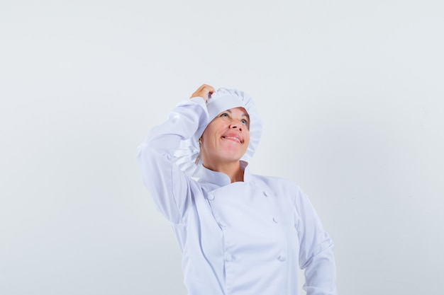 Chef de femme se gratter la tête en uniforme blanc et à la pensif