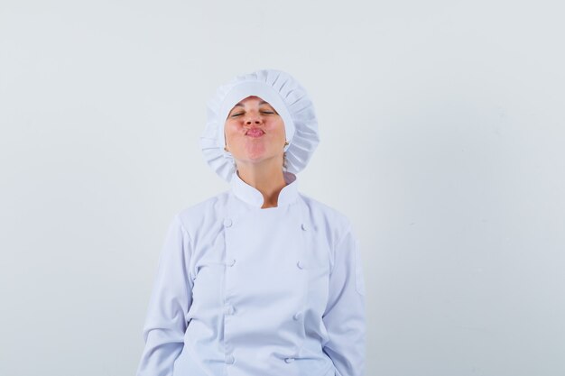 Chef de femme en uniforme blanc lèvres boudeuses et à la mignon