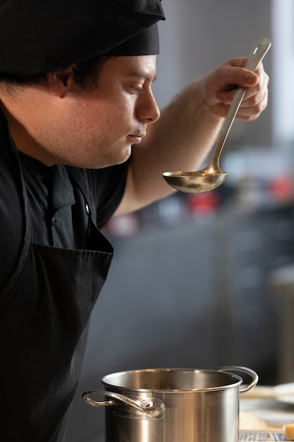 Chef masculin dans la cuisine, dégustation de la nourriture