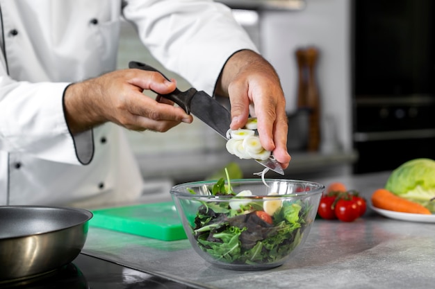 Photo gratuite chef masculin dans la cuisine préparant la salade