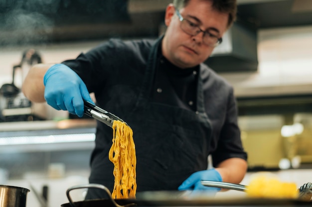 Photo gratuite chef masculin avec des gants de pâtes