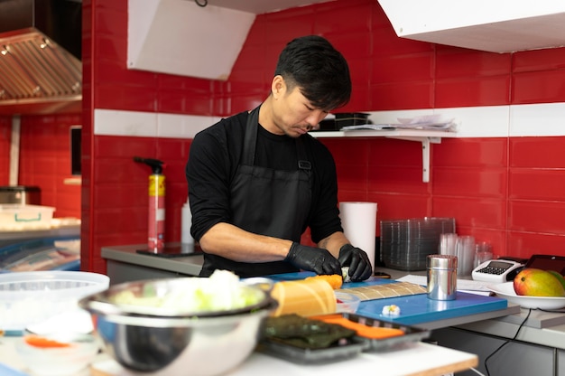 Chef masculin préparant une commande de sushi pour un plat à emporter