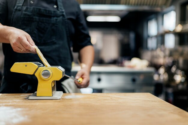 Chef masculin roulant la pâte de pâtes fraîches