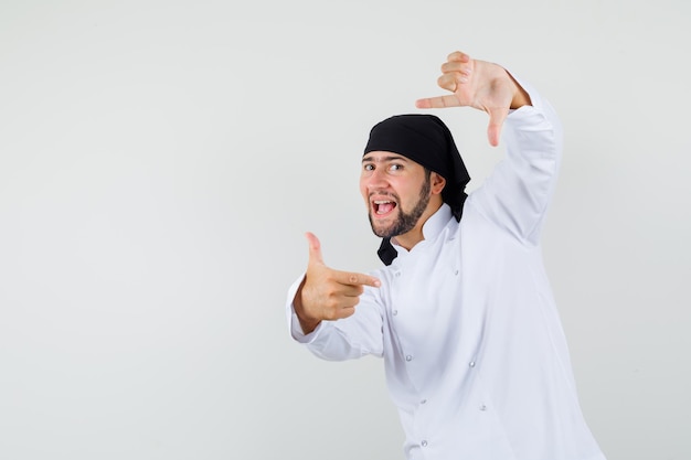 Chef Masculin En Uniforme Blanc Faisant Un Geste De Cadre Et Semblant énergique, Vue De Face.