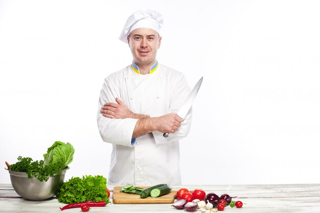 Chef posant avec couteau dans sa cuisine