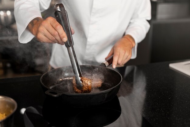 Chef professionnel préparant la nourriture dans la cuisine