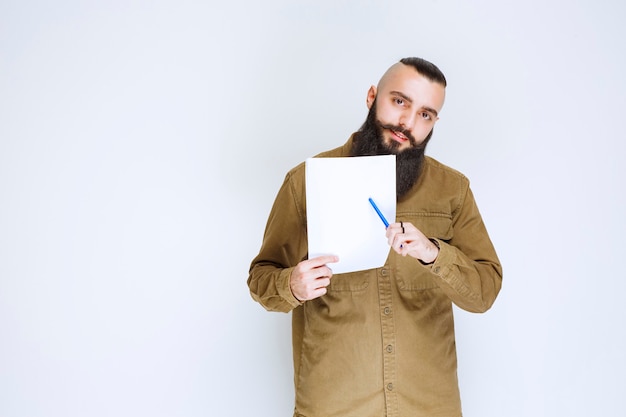 Le chef de projet montre les rapports à son collègue et note les erreurs ou les corrections.