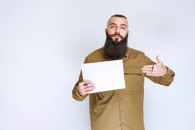 Le chef de projet montre les rapports à son collègue et note les erreurs ou les corrections.