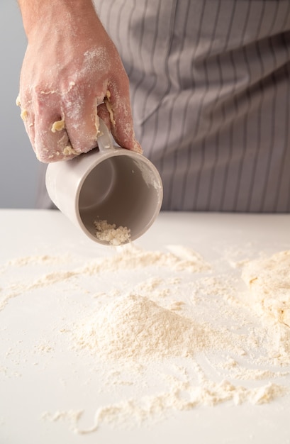 Photo gratuite chef saupoudrant la farine sur la surface de travail