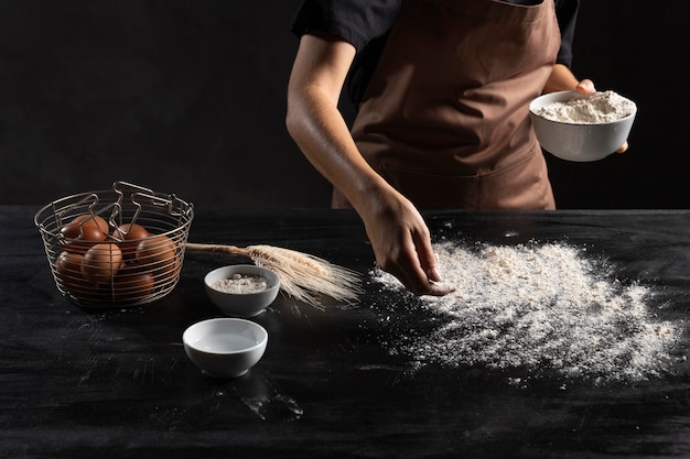 Chef saupoudrer la table de farine pour pétrir la pâte