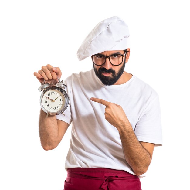 Chef tenant une horloge sur fond blanc