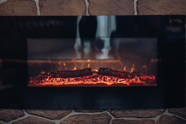 Cheminée avec des bûches brûlantes. Gros plan sur une cheminée de pierre avec des bûches brûlantes ou fumantes en feu.