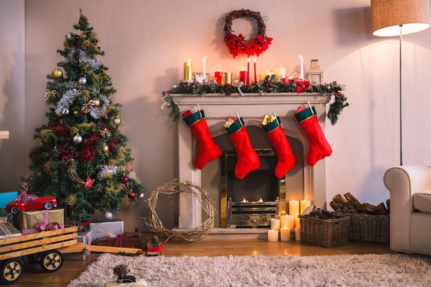 Cheminée avec des chaussettes rouges suspendus et un arbre de Noël