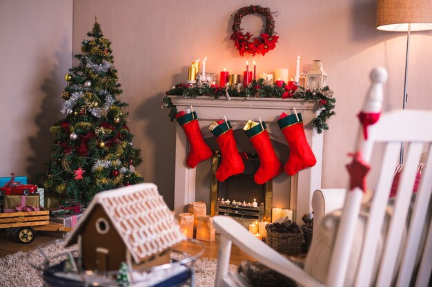 Cheminée décorée avec des motifs de Noël et chaussettes rouges