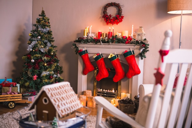 Cheminée décorée avec des motifs de Noël et chaussettes rouges