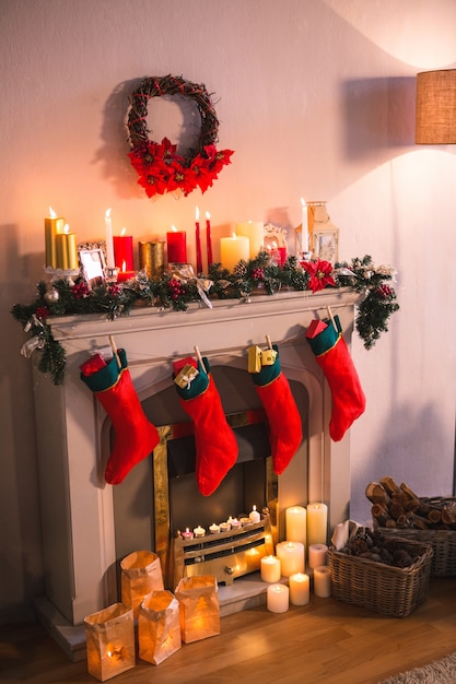 Cheminée décorée avec des motifs de Noël et chaussettes rouges