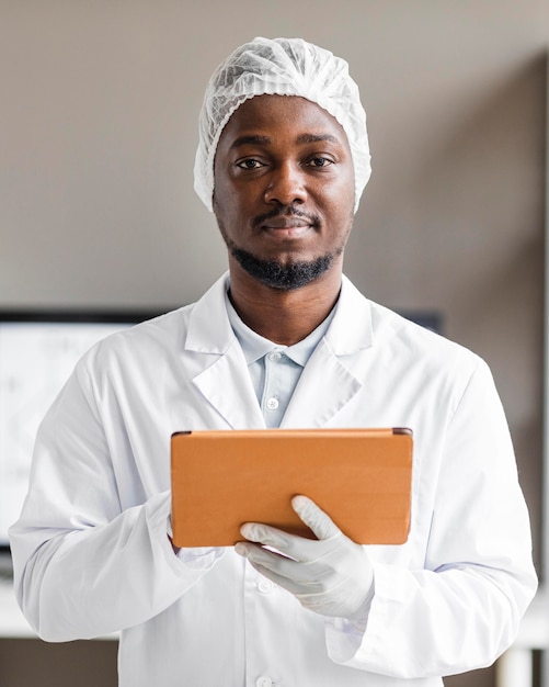 Chercheur masculin Smiley dans le laboratoire de biotechnologie avec tablette