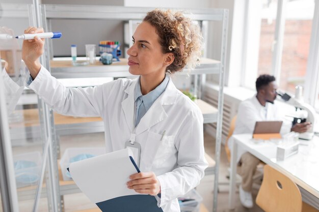 Chercheur avec presse-papiers dans le laboratoire de biotechnologie