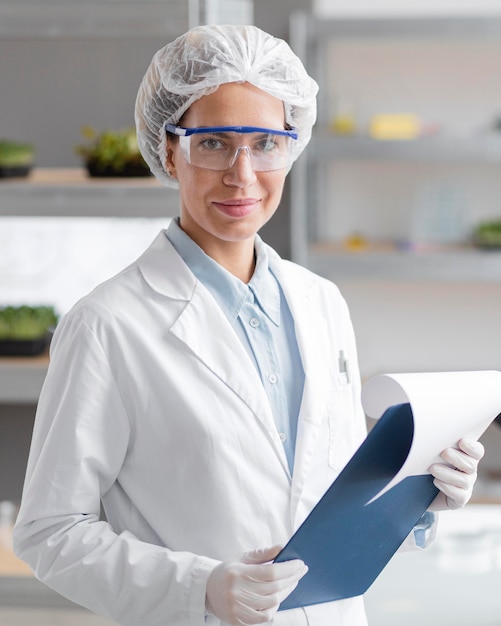 Chercheur Smiley avec presse-papiers dans le laboratoire de biotechnologie