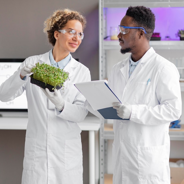 Photo gratuite chercheurs en laboratoire avec usine de contrôle de lunettes de sécurité