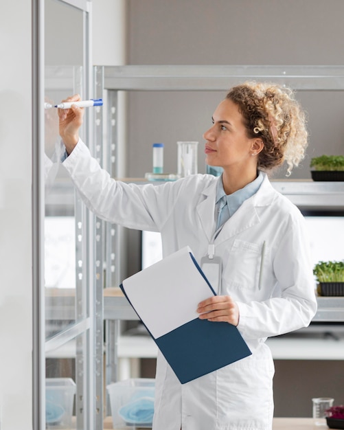 Chercheuse avec presse-papiers dans le laboratoire de biotechnologie