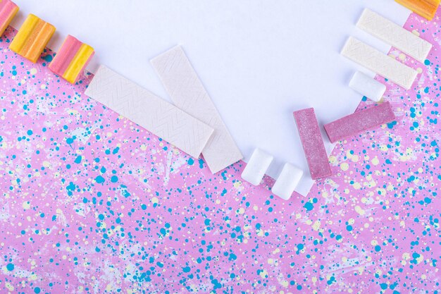 Chewing-gums bordant un tableau blanc sur une surface colorée