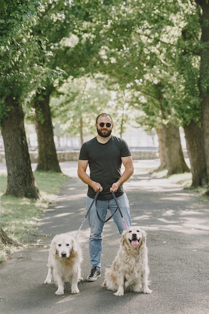 Chien-guide aidant un aveugle dans la ville. Beau mec aveugle se repose avec golden retriever dans la ville.