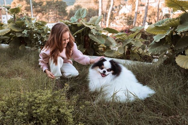 Photo gratuite chien mignon et fille jouant dans le jardin