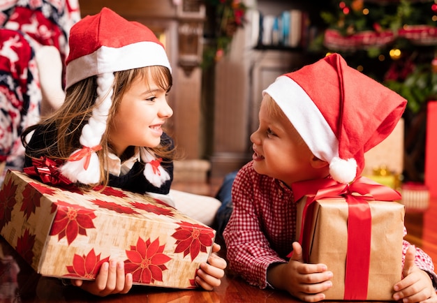 Childrens regardant les uns les autres avec des cadeaux