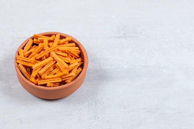 Chips de bâton épicées dans un bol en céramique.