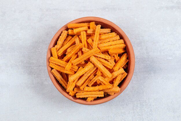 Chips de bâton épicées dans un bol en céramique.