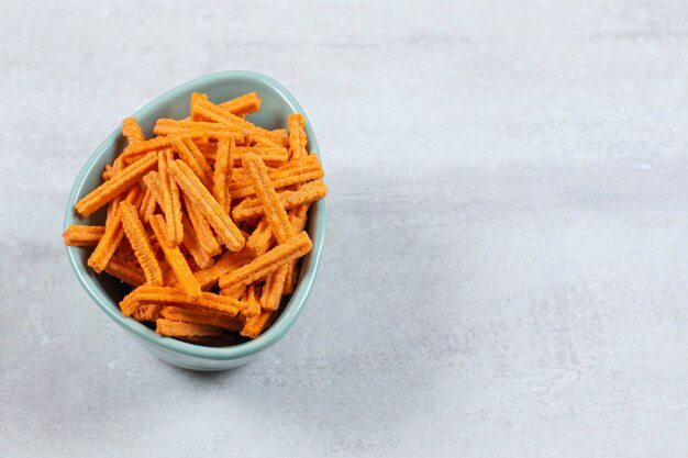 Chips de bâton savoureux dans un bol bleu.