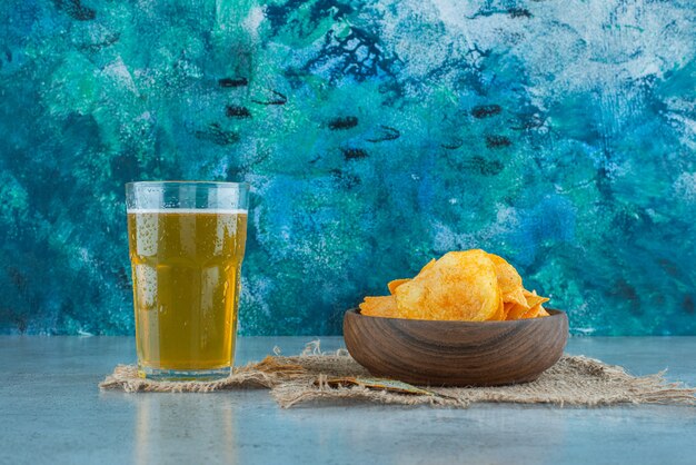 Chips et bière sur les textures, sur le fond de marbre.