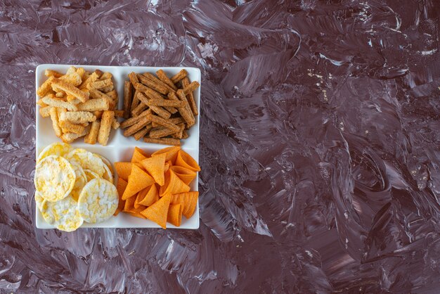 Chips avec de la chapelure dans un bol , sur la table en marbre.
