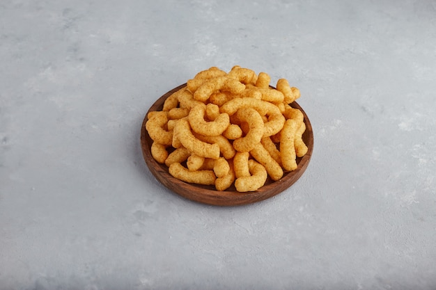 Chips de maïs aux épices dans un plateau en bois, vue du dessus.