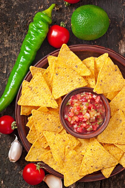 Chips de nacho mexicain et trempette de salsa dans un bol en bois