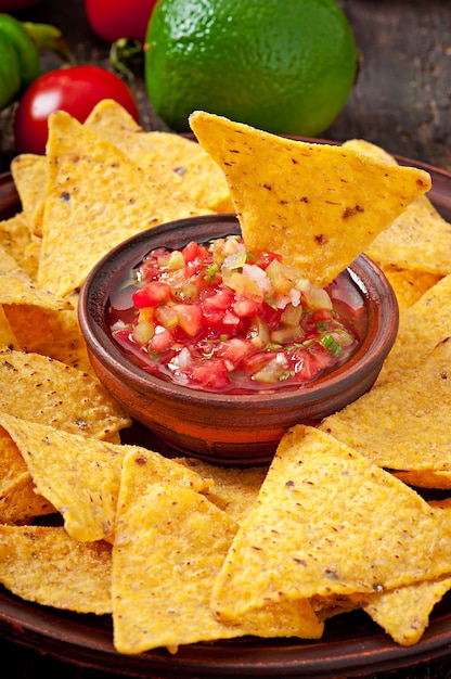 Photo gratuite chips de nacho mexicain et trempette de salsa dans un bol en bois