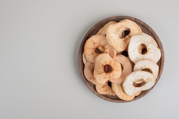 Chips de pommes séchées sur plaque en bois