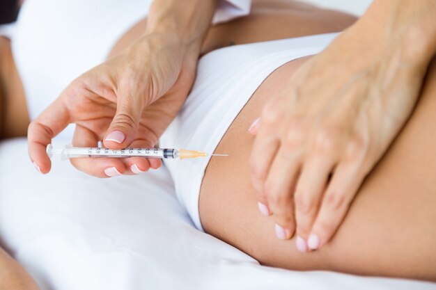 Chirurgien faisant l&#39;injection dans le corps de la femme. Concept de liposuccion.