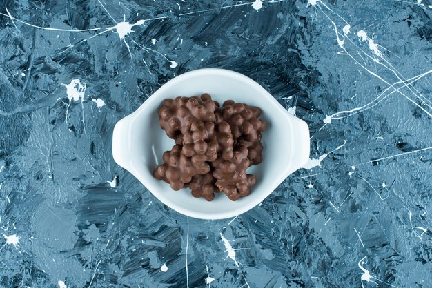 Chocolat aux noisettes dans un bol, sur la table bleue.