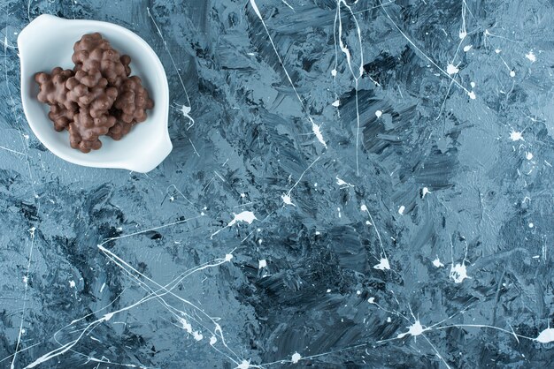 Chocolat aux noisettes dans un bol, sur la table bleue.