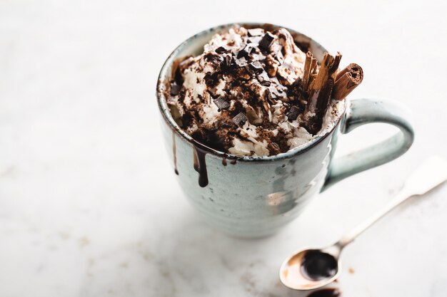 Chocolat chaud dans une tasse avec de la crème fouettée